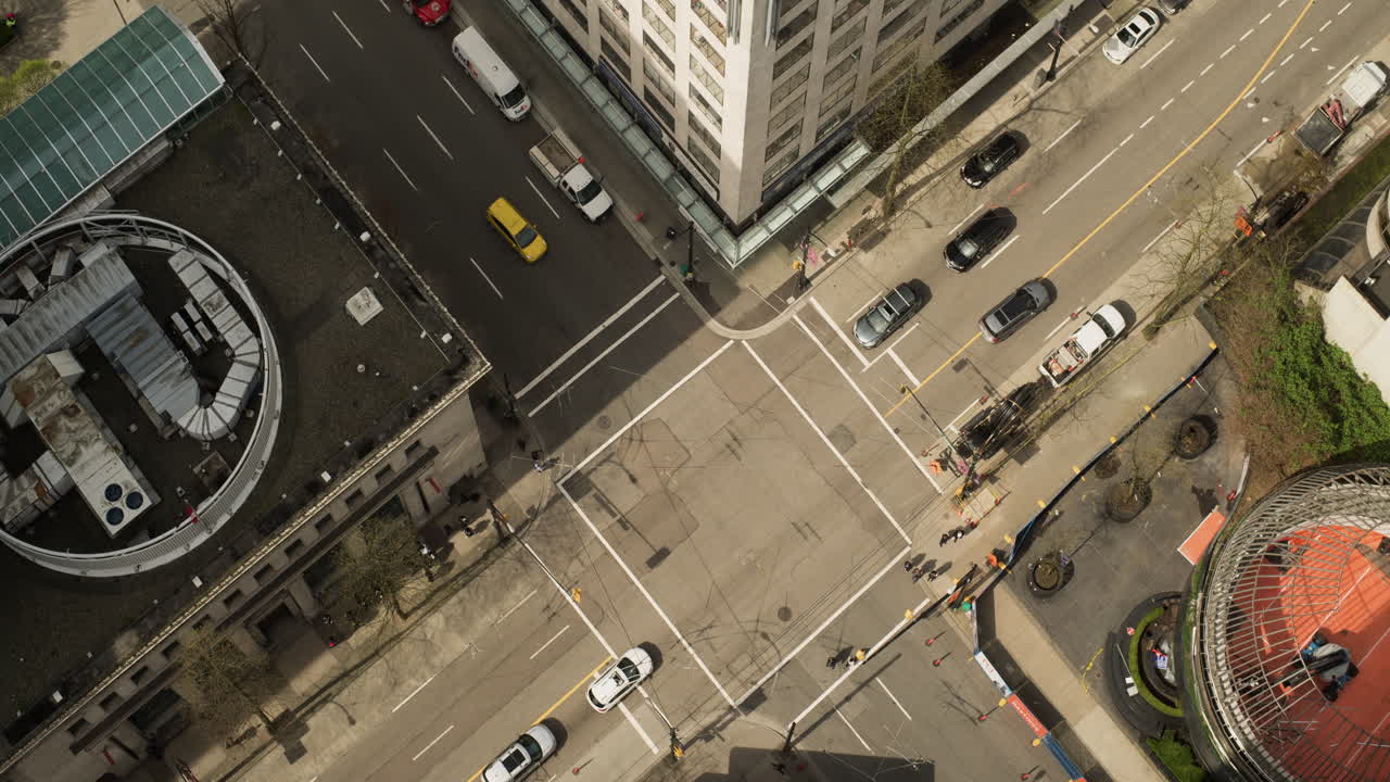 Time lapse from above of busy downtown Vancouver intersection with pedestrians and traffic in motion, Sunny day