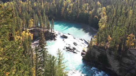 dolly-in-aerial-zoom-in-shot-of-Rearguard-Falls-drone-flying-through-trees-towards-the-waterfalls-on-a-sunny-day-in-autumn-in-a-forest-environment-and-the-fraser-river