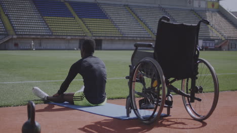 disabled athlete stretching outdoors at sports facility