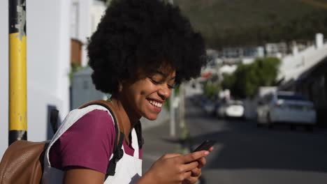 Mixed-race-woman-on-smartphone-on-sidewalk