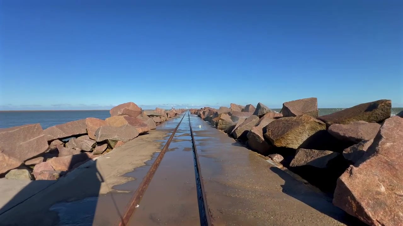 Fremadgående kamera ombord langs betongskinnebanen ved Molhes da Barra i Rio Grande, Brasil