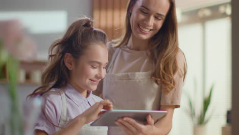 happy mother and daughter using tablet