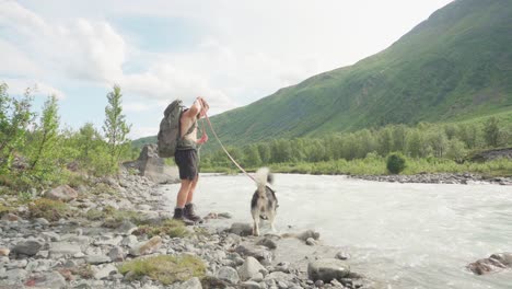 Man-travelling-with-his-dog-trying-to-cross-a-river