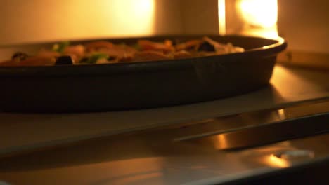 homemade pizza being placed into oven. slow motion