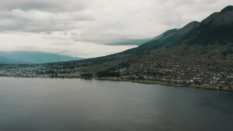 san pablo lagoon and hillside town with rising imbabura volcano heights in otavalo, ecuador