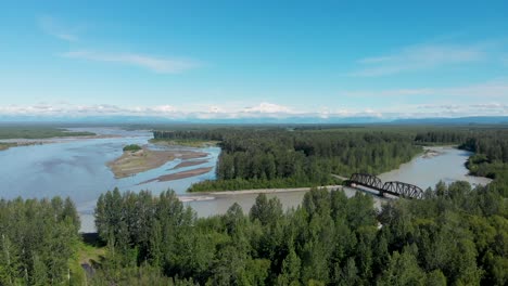 4k drone video of alaska railroad train trestle with mt