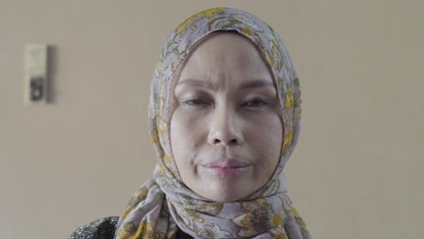 muslim woman looking slightly disappointed into camera zoom in