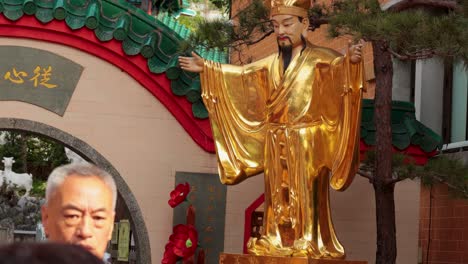 visitors admire a golden statue in hong kong