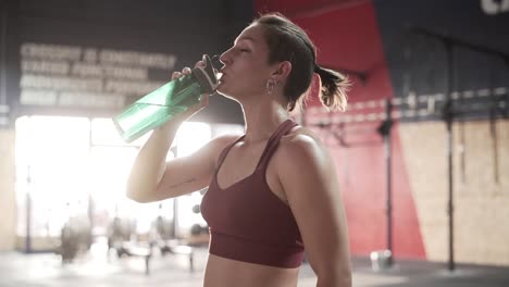 woman drinking water at gym