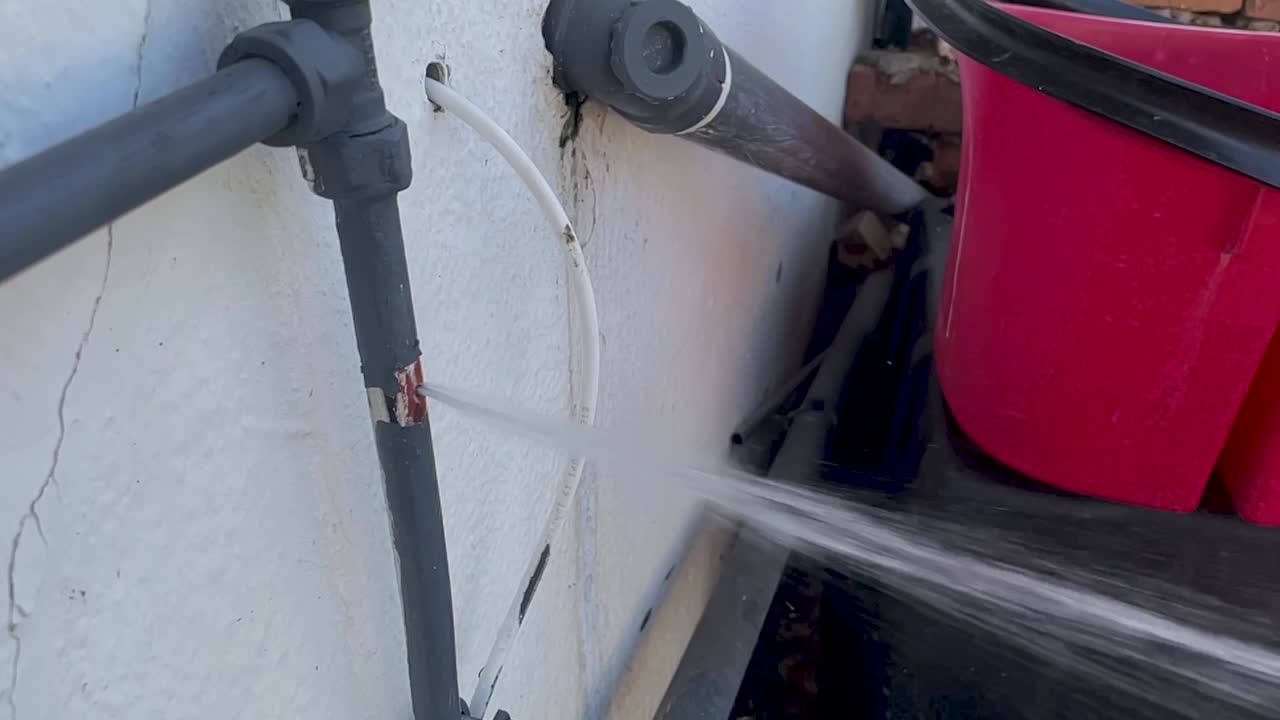 tiro estático en cámara lenta de una tubería estalló disparando agua desde un agujero en una tubería