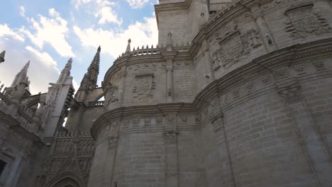 gothic architecture of seville cathedral with ornate details under a partly cloudy sky