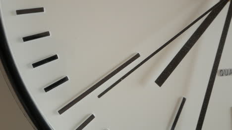 stuck second hand of a broken white wall clock ticks repeatedly, close up shot