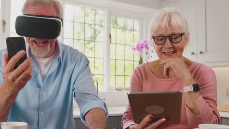 retired senior couple at home using digital tech with tablet vr headset smartwatch and mobile phone