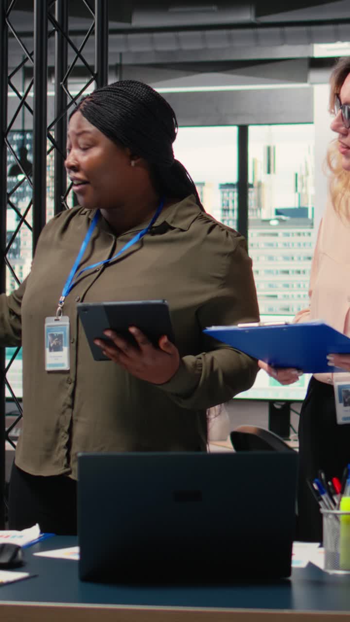 Vertical Video Diverse women professionals focus on report writing and analytics