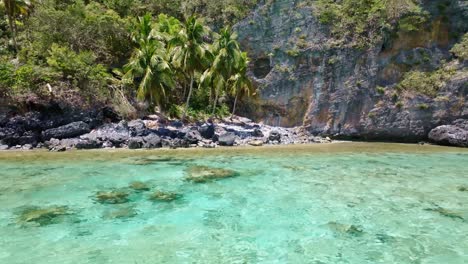 Agua-Cristalina-De-Playa-Frontón-Con-Acantilados-Rocosos-Al-Fondo-En-Las-Galeras,-Samana,-República-Dominicana