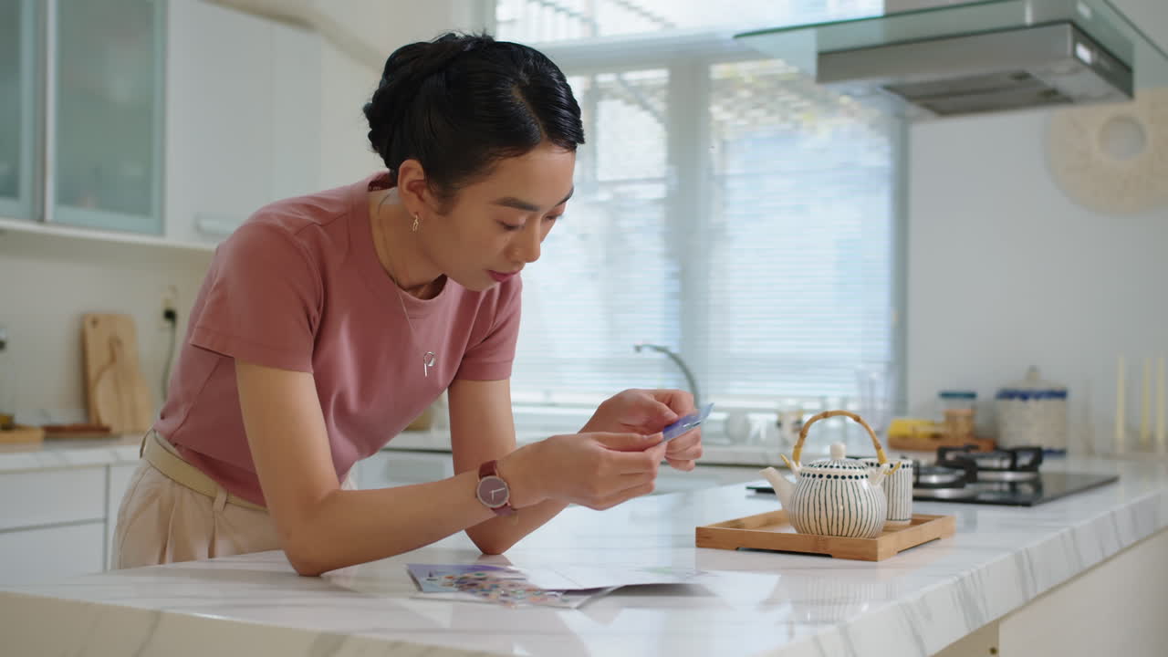 Donna asiatica che decora una carta di credito con degli sticker