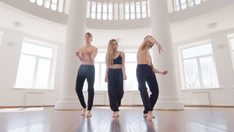 three professional contemporary dancers training dance moves in the studio 6