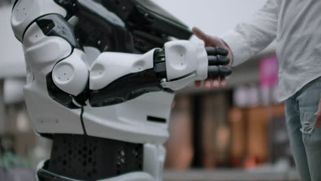 interacción del hombre y las tecnologías modernas de inteligencia artificial. cerca de la mano masculina del científico sacude el brazo robótico. manos robóticas y humanas se unen en un apretón de manos. reunión y saludo de amigos.