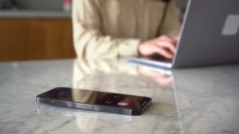 mujer trabajando en el fondo sin texto de notificación telefónica y llamada telefónica en su teléfono inteligente mientras se concentra en su trabajo