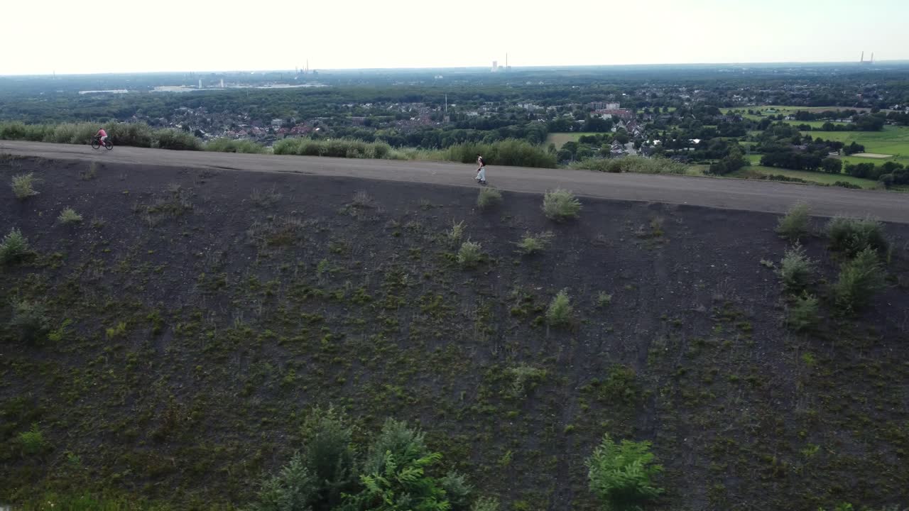 People Cycling on a Hill Road