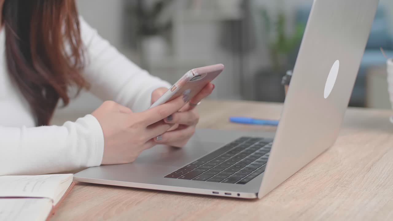 Hands Girl Using Mobile Phone During Work On Laptop Computer, Video In 4K
