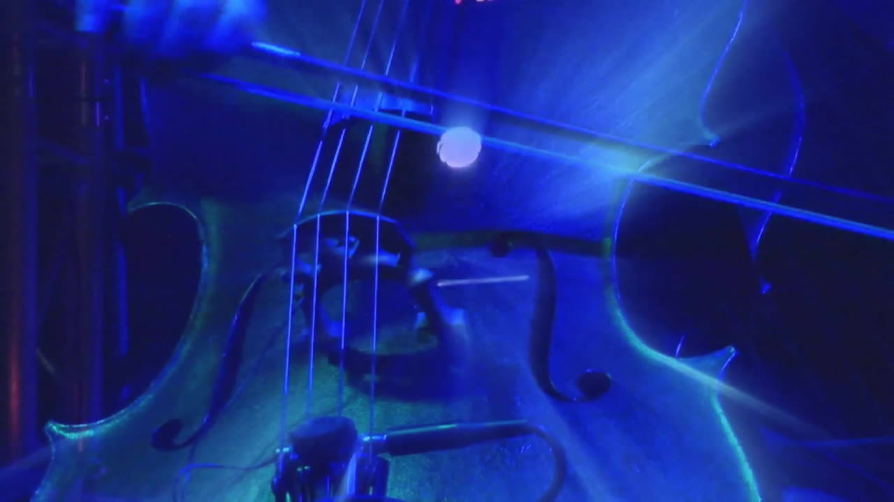 Close-up of cello strings and bow with blue light animation