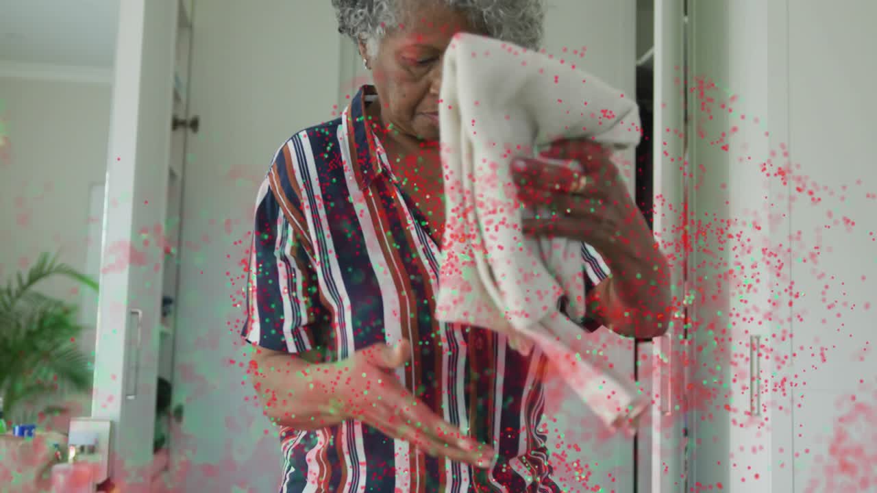 Senior woman walking in holding cloth, inspecting and folding while particles sweeping for travel