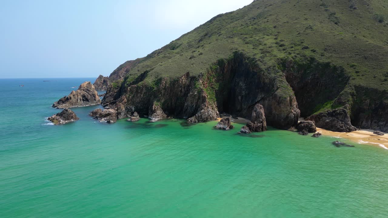 Drone rotating shot over cliffs next to sandy beach