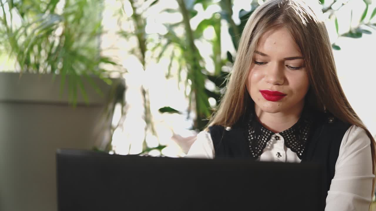 카페에서 노트북으로 일하는 젊은 여성