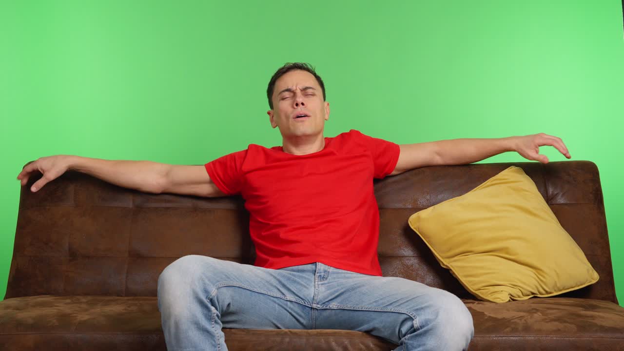 Man sitting on sofa changing position and falling asleep on green screen