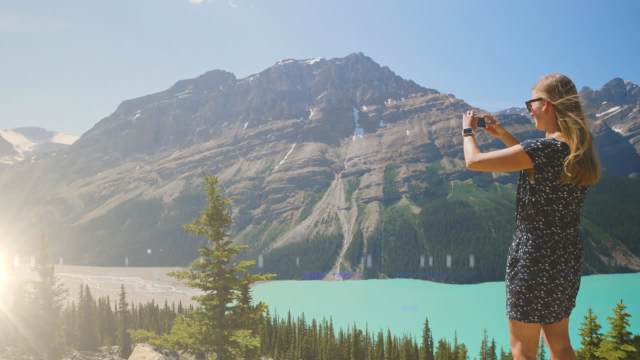 백인 여성이 산의 풍경 사진을 찍고 있는 빛의 애니메이션