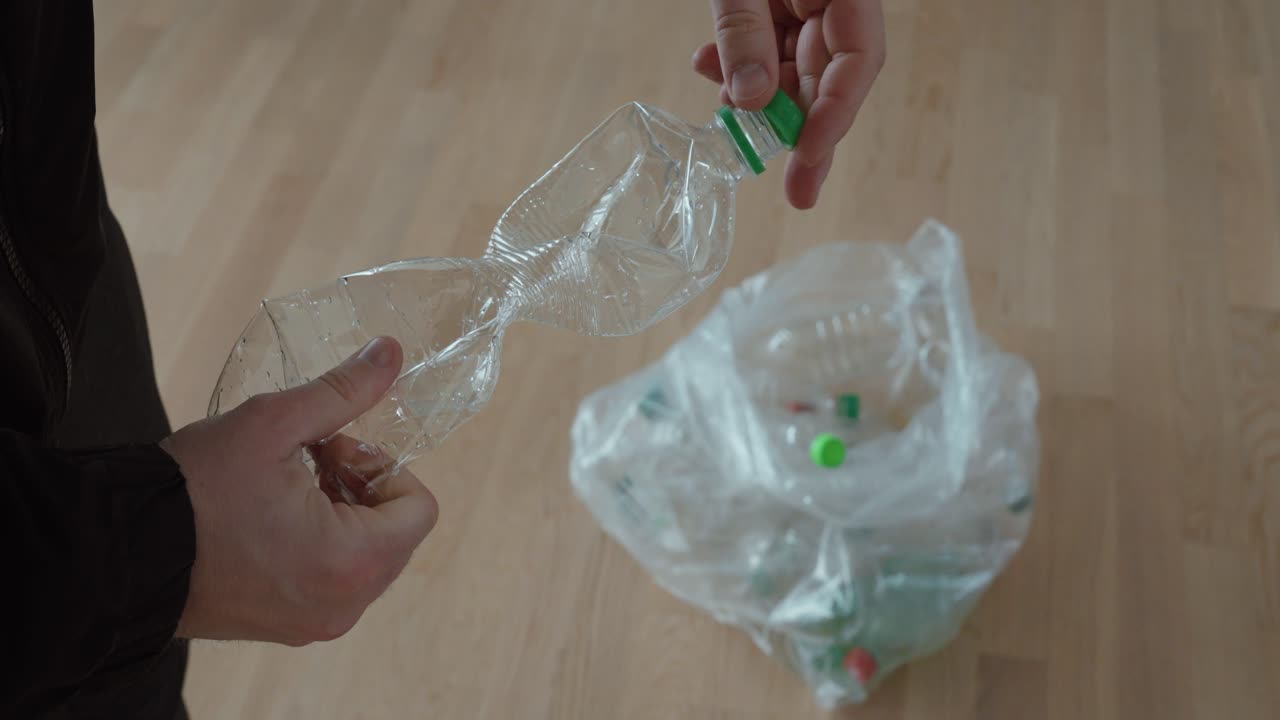 Primo piano di mani che rimuovono un tappo da una bottiglia di plastica vuota prima di metterla in un sacco per la raccolta differenziata, evidenziando la selezione responsabile dei rifiuti e le abitudini domestiche sostenibili