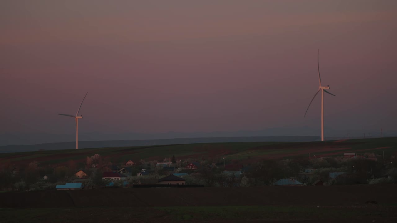 Wind Turbines and Village at Sunset