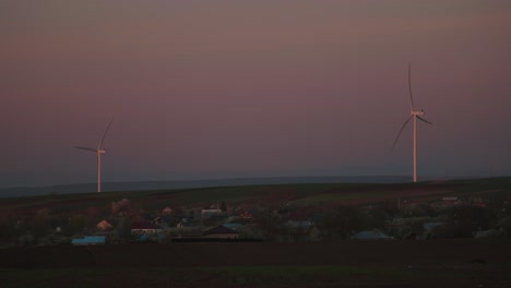 wind turbines and village at sunset
