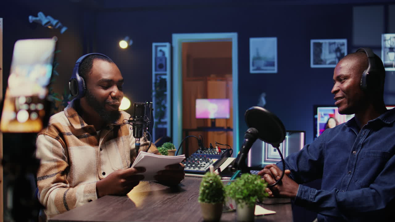 Men laughing during comedy focused podcast filmed with smartphone on tripod