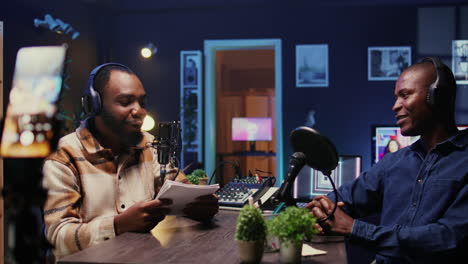 hombres riendo durante un podcast enfocado en la comedia filmado con un teléfono inteligente en un trípode