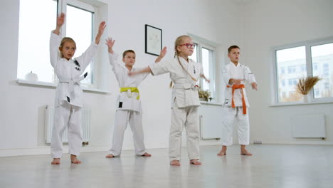 niños en kimono blanco en la clase de artes marciales