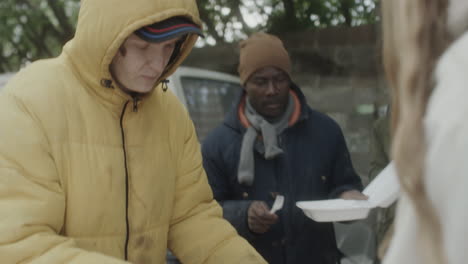 people receiving meals at an outdoor charity food distribution