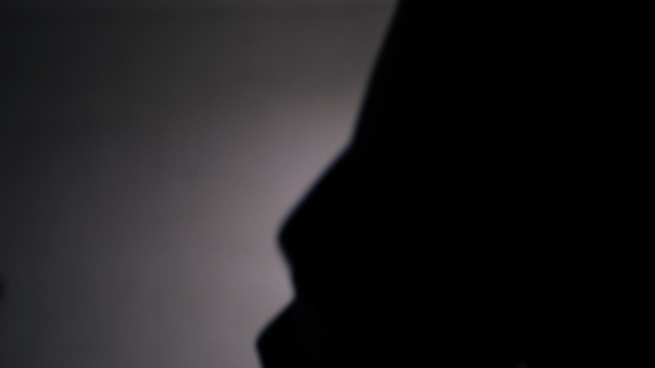 살인 피해자를 공격하기 위해 무서운 칼을 실루엣으로 들고 있는 무서운 슬래셔 킬러