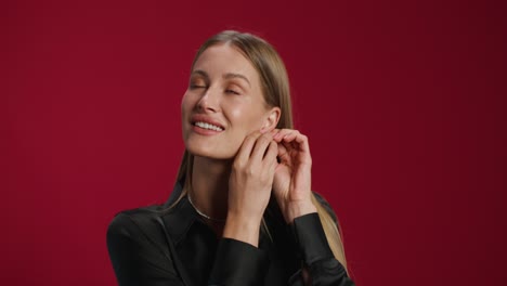 woman putting on earrings
