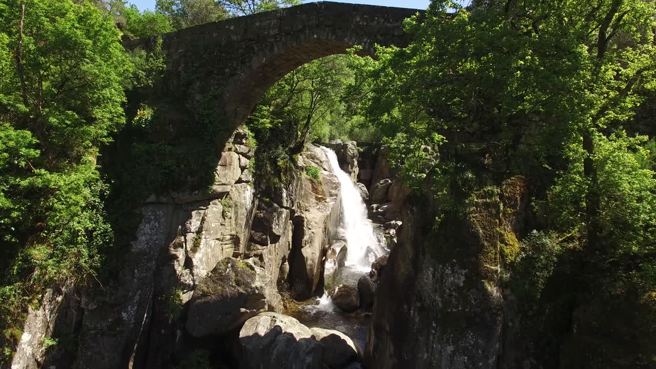 Hidden Waterfall Under Ancient Bridge