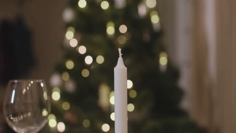 camera focuses on man's hands lighting a candle for christmas dinner