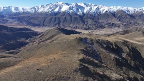 Beautiful-winter-day-above-Mount-Barossa,-aerial-view-of-majestic-snowy-mountain-range-and-valley