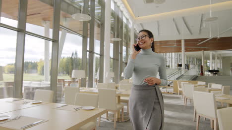 woman using smartphone in a modern restaurant or hotel lobby