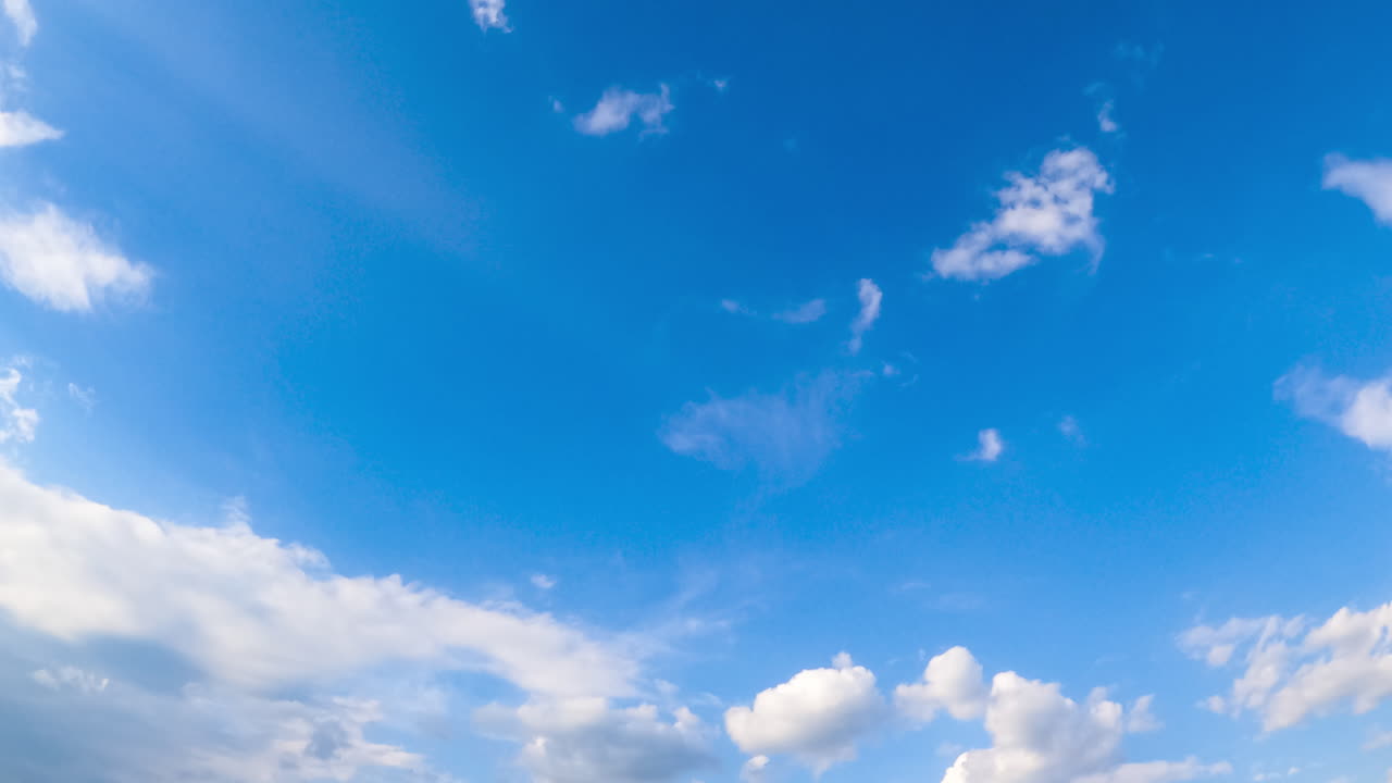 Amazing clear azure sky in summer. Cumulus clouds covering the horizon and sun. Low angle view. Timelapse.
