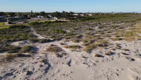 dron aéreo sobre la ciudad costera panorámica hacia abajo para revelar playa de arena blanca