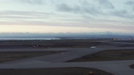 Antena-Del-Hermoso-Paisaje-Del-Amanecer-Del-Aterrizaje-Del-Jet-De-Negocios-En-La-Pista-De-Aterrizaje-De-Islandia