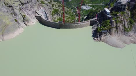 aerial drone backward moving shot over hotel grimsel hospiz in grimsel pass, swiss mountain, switzerland on a sunny day