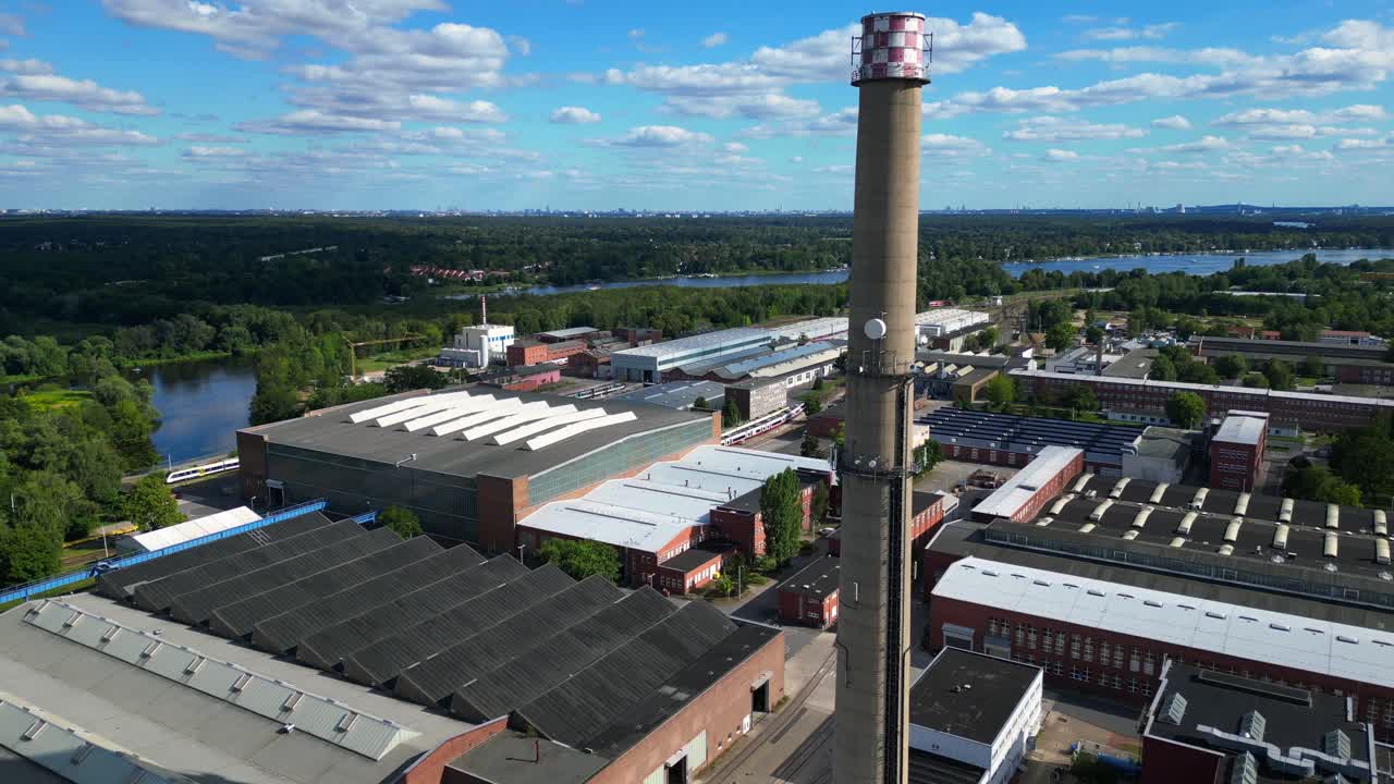 Hennigsdorf steel industry with industrial buildings, chimneys, storage area and a river in the background. Nice aerial view flight very close passing flight drone