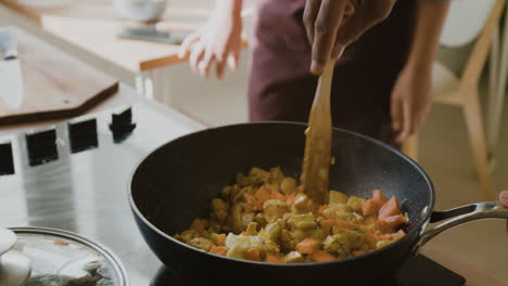 cooking chicken and vegetable curry in a pan